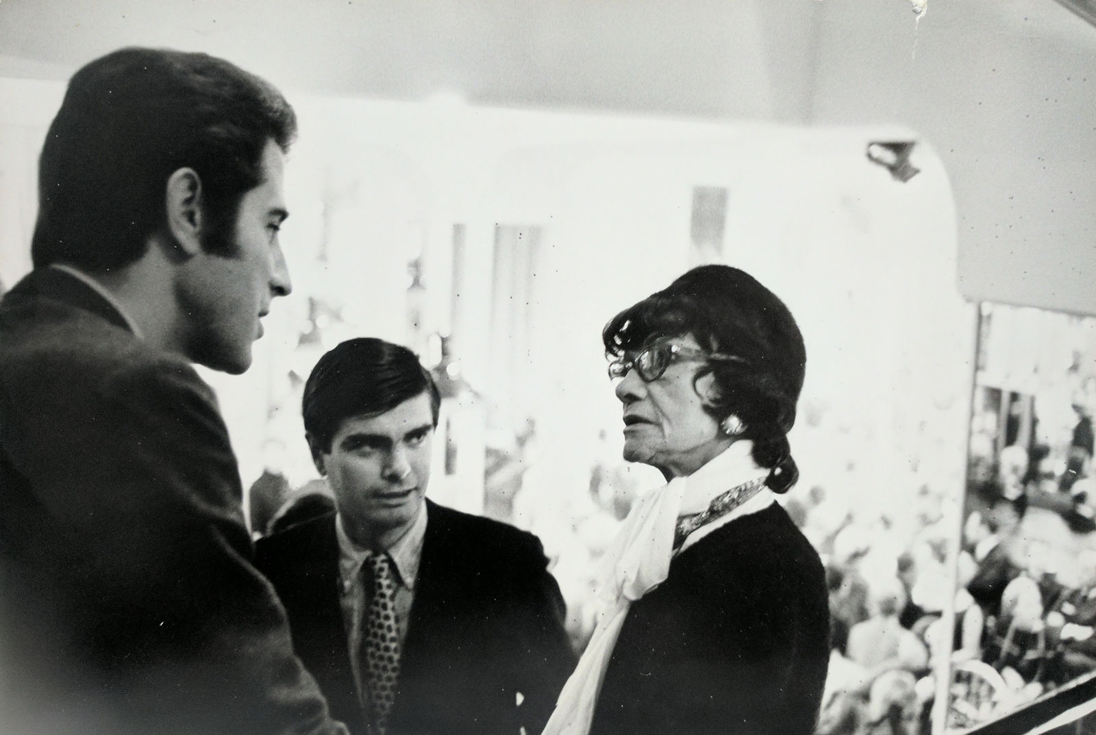 Black and white photograph of Chanel speaking to James Brady, publisher of Women’s Wear Daily inside the House of Chanel