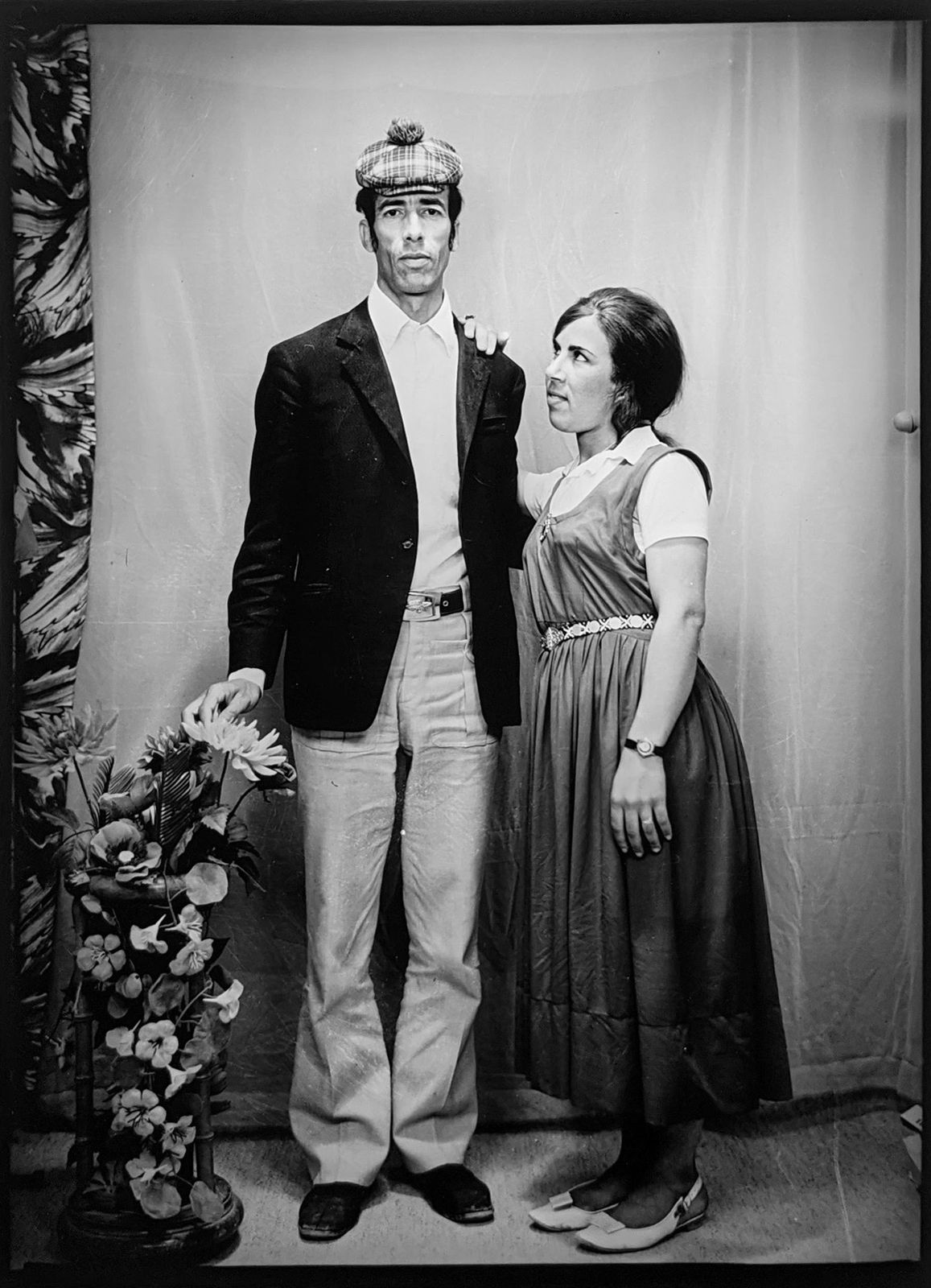 1960s black and white photograph of a woman looking out to the left in profile and a man standing and looking directly at the camera