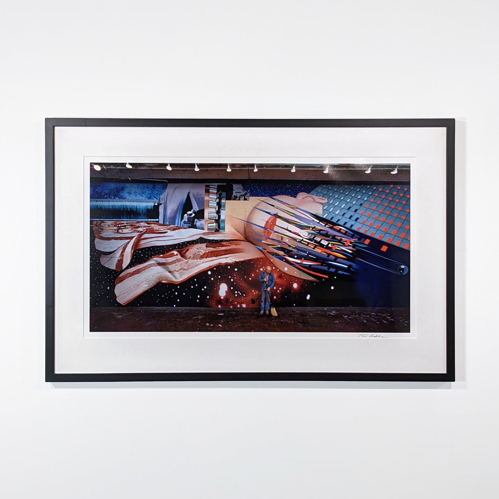 Framed Photograph of James Rosenquist sweeping in front of a mural of a woman’s face and strips of bacon in a galactic scene