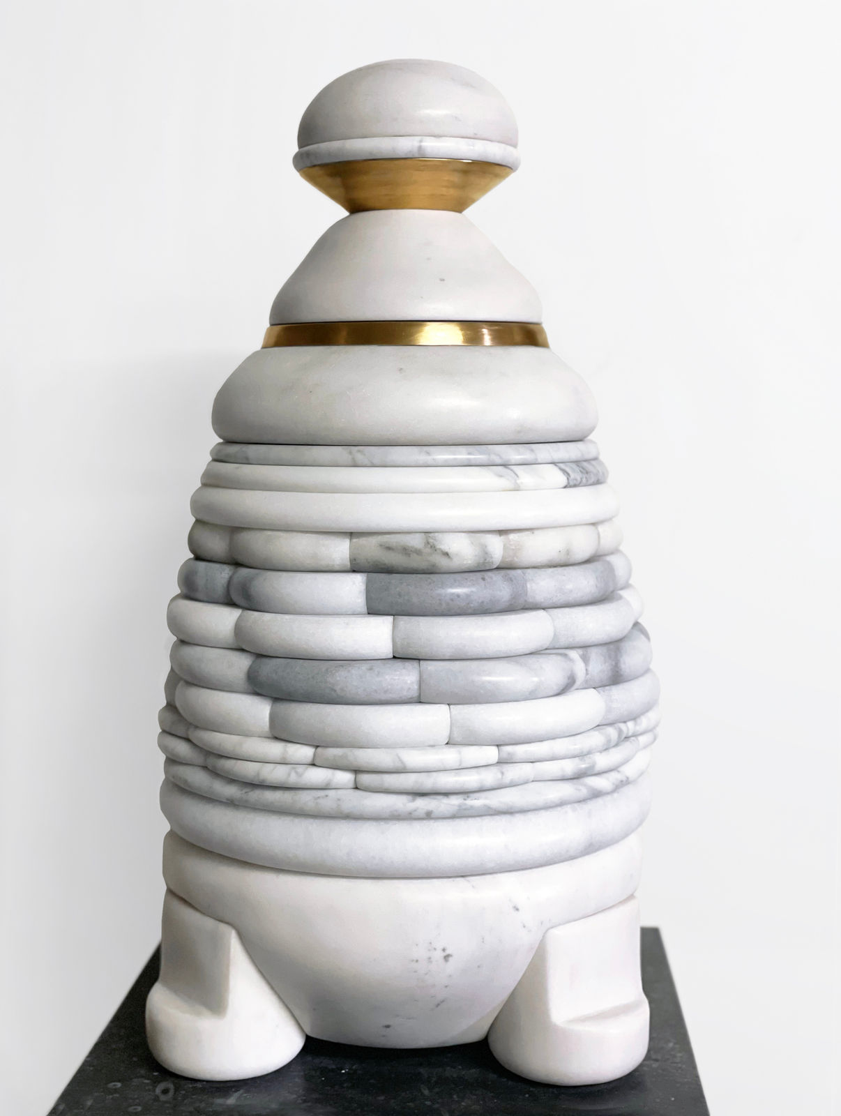 Medium-sized sculpture comprising layers of foliated marble, brass, and stone of varying color and thickness