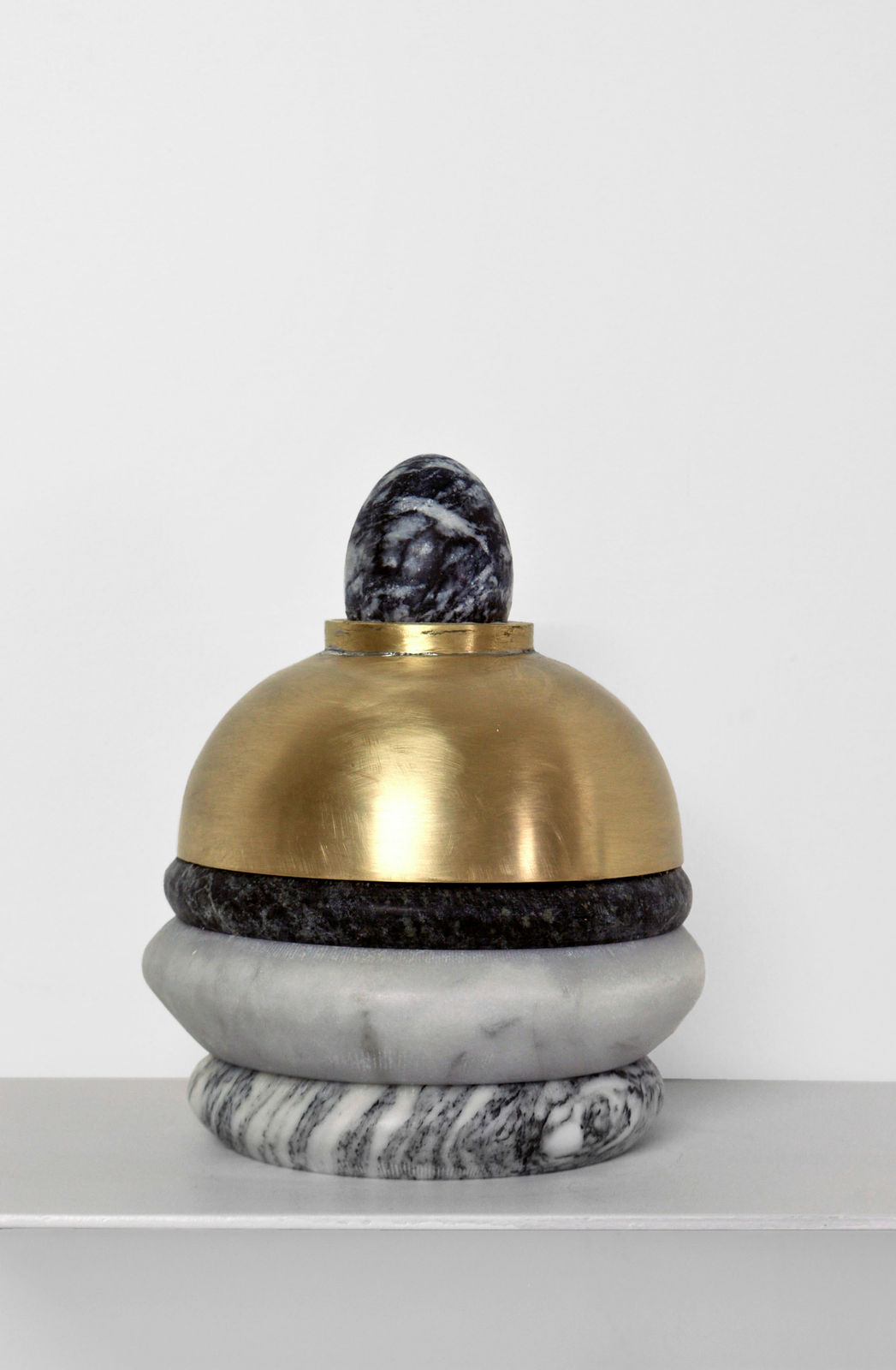 Contemporary minimalist sculpture made of stone and metal that resembles an ambiguous artifact