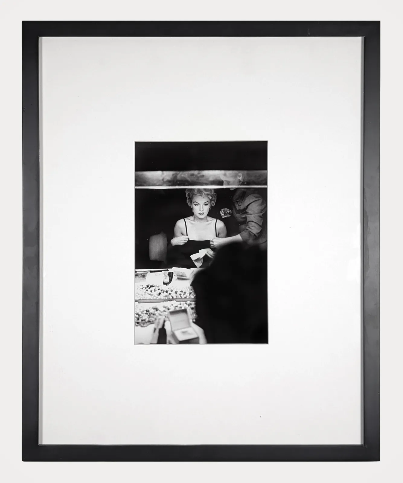 Framed black and white photograph of Marilyn Monroe looking at her makeup in the dressing room mirror of Carol Haney in New York City, 1954
