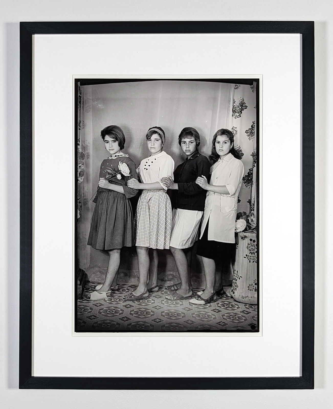 framed 1960s black and white photograph of four women in a row looking at the camera