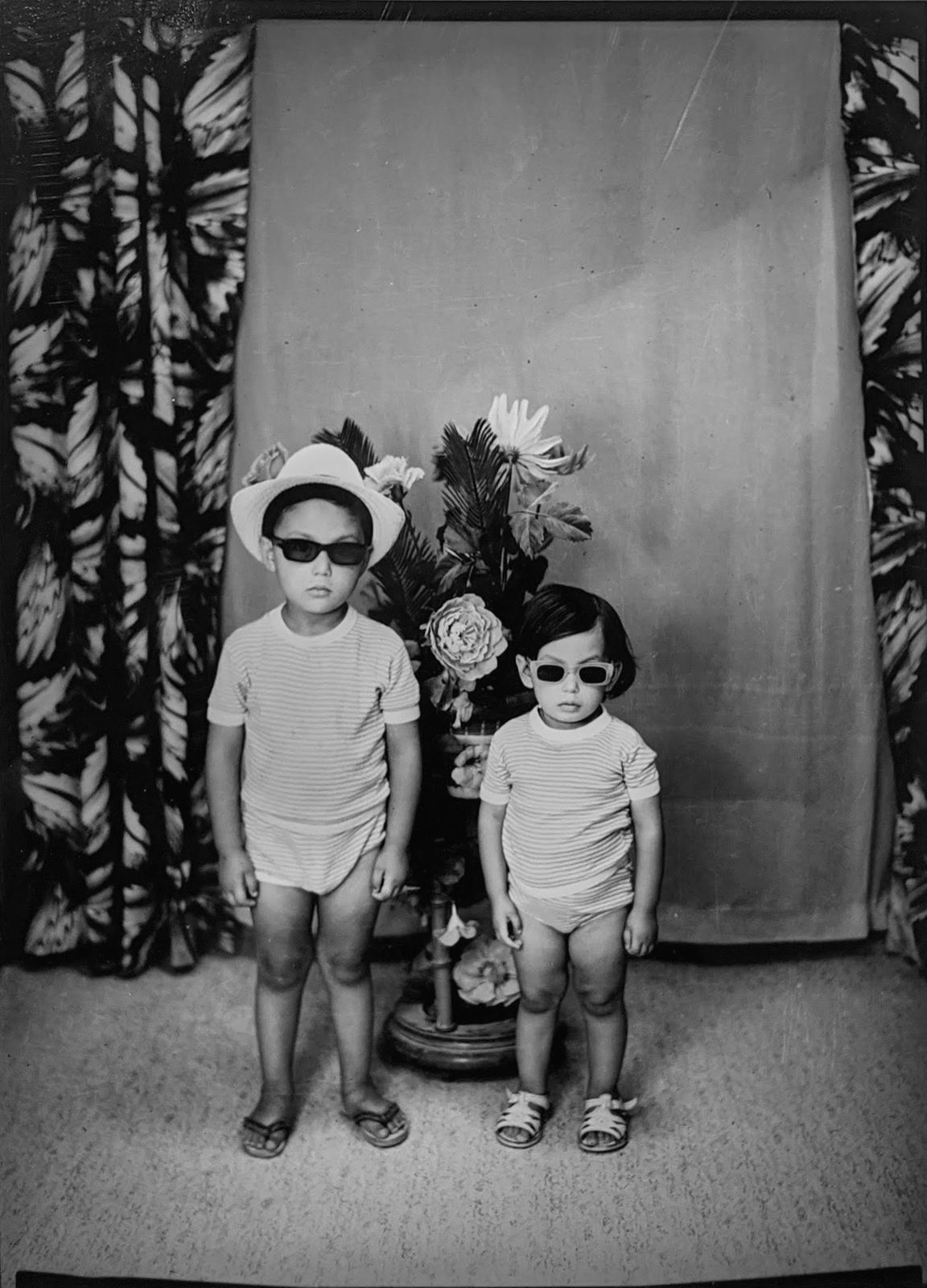 1960s black and white photograph of two young boys wearing all white with sunglasses