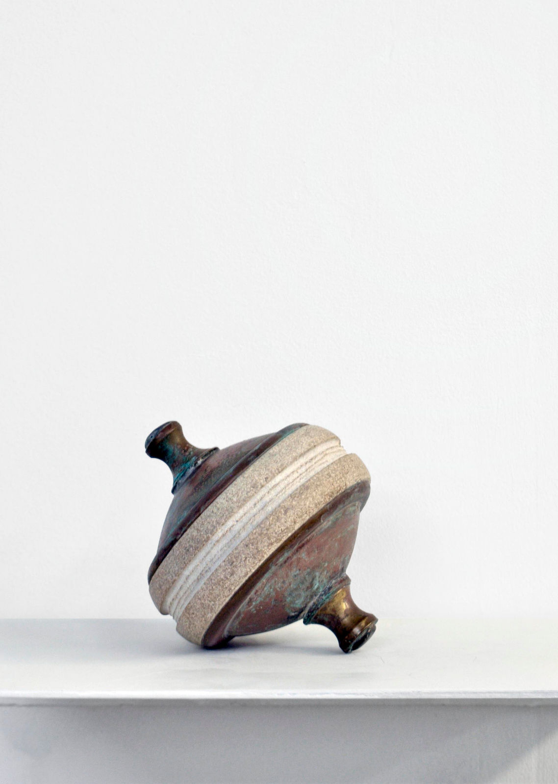 Contemporary minimalist sculpture made of stone and metal that resembles an ambiguous artifact
