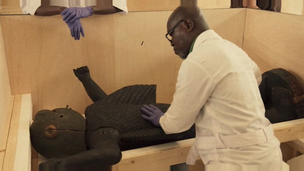 Museum workers carefully positioning an artefact following its arrival.