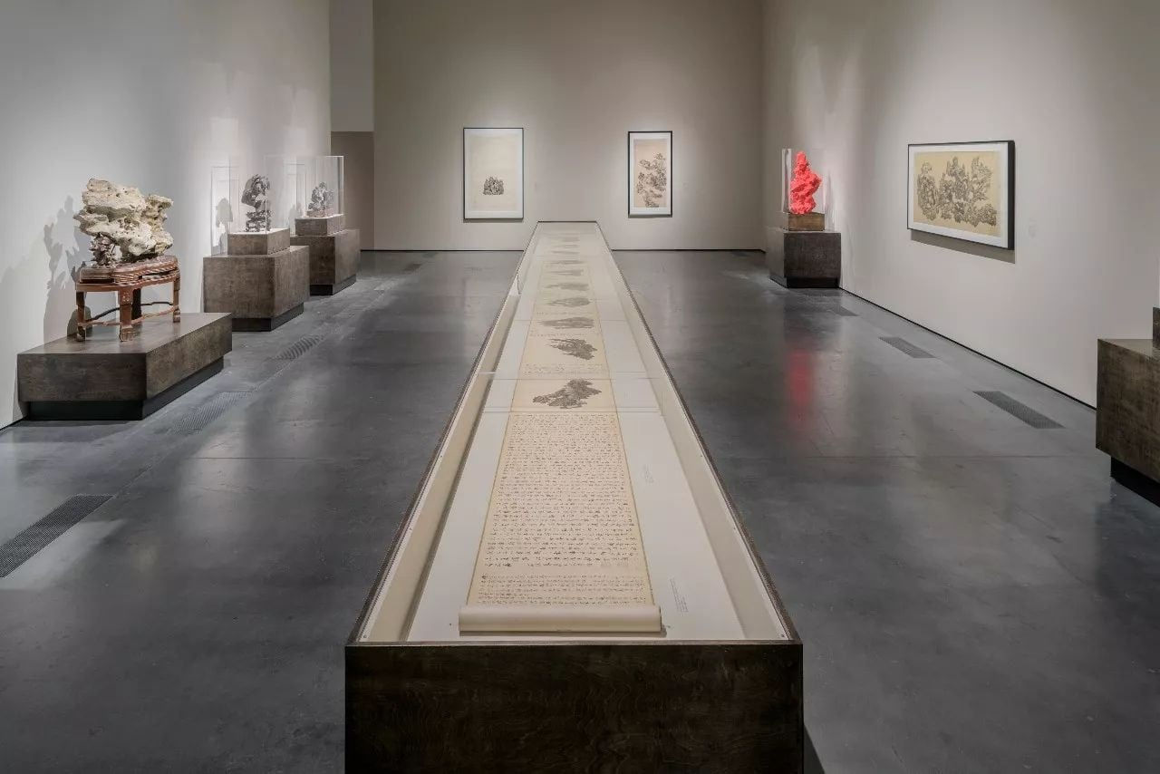 museum space that has a long scroll of Wu Bin's painting display on the center and more painting and scholar rock showed on the side