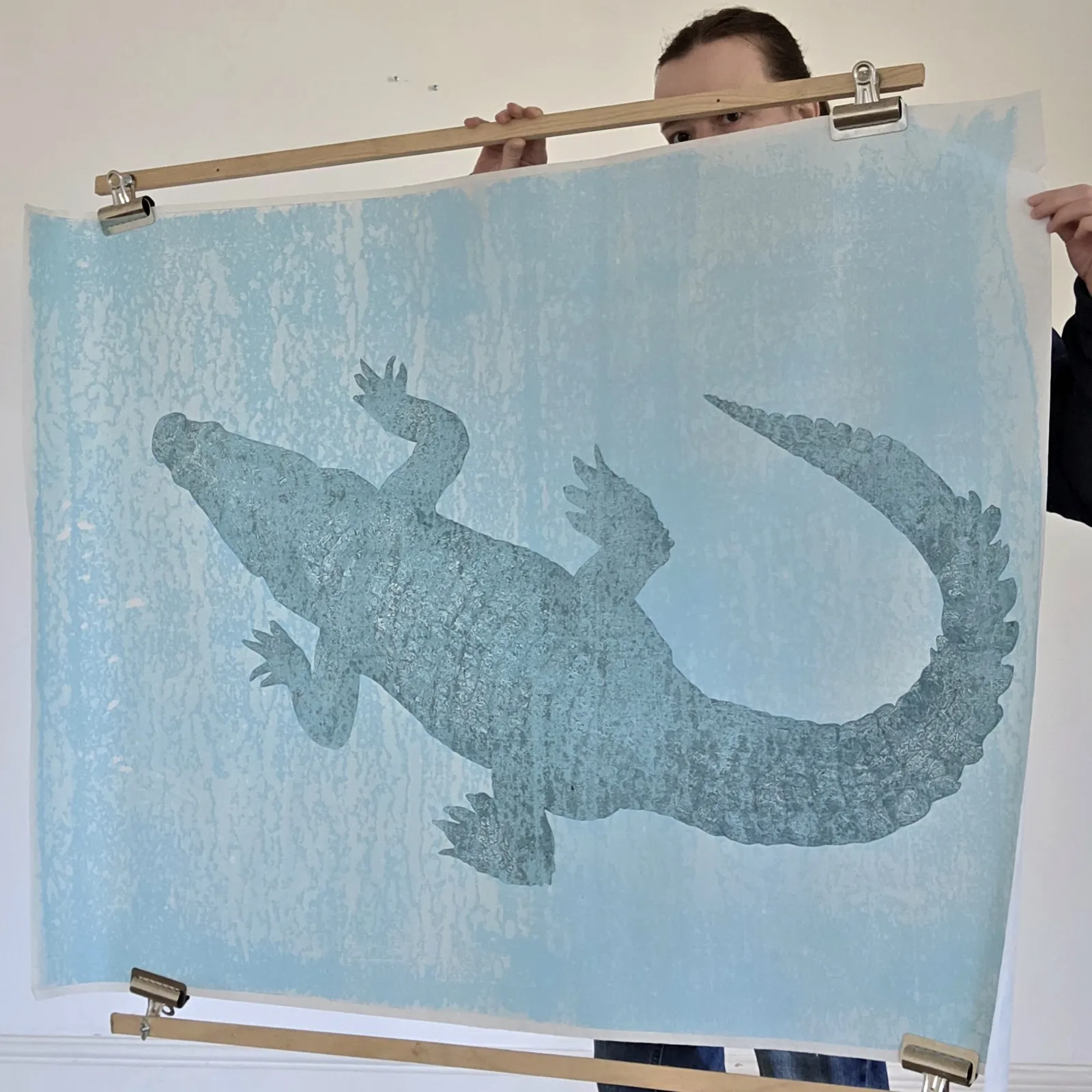 Linocut art print of a crocodile under blue water by Nicola Wallis