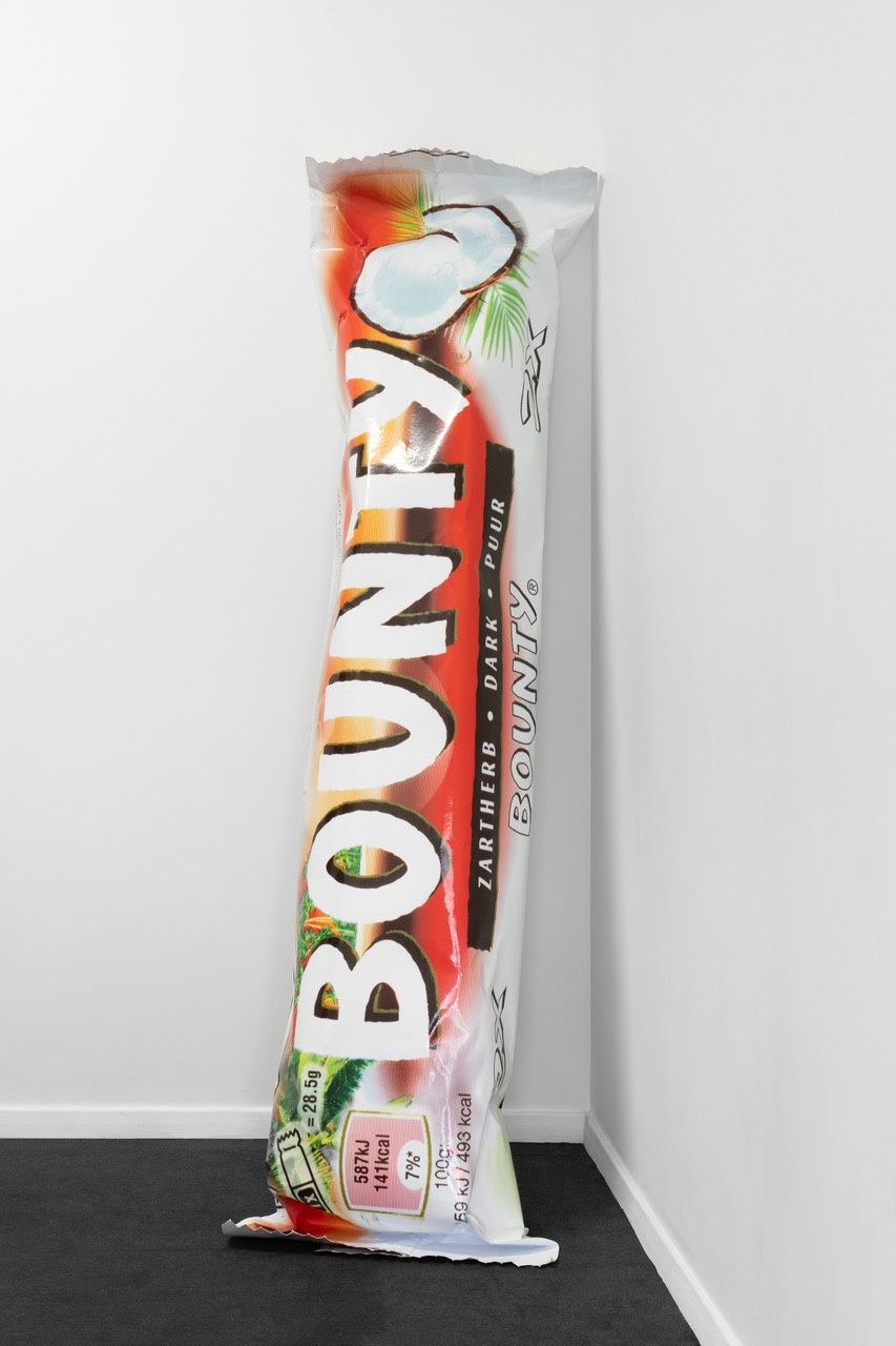 Léo Luccioni Mutiny on the Bounty, A Taste of Nostalgia (Apologies to Tarita for no Bounty in Celebrations chocolates Box), 2023 CMYK ink on car vinyl, UV protective varnish, paper, foam, epoxy, wood glue 235 x 40 x 36 cm. 92.5 x 15.7 x 14.1 in.