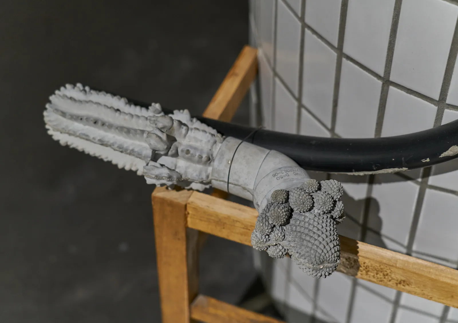 Leaning 倚靠 (detail 局部), ZHANG Ruyi 张如怡, 2022/2026. Rubber pipes, concrete, remodeled wooden chair, bitumen, metal 橡胶管、混凝土、改装木制椅子、沥青、金属, Variable Size 尺寸可变