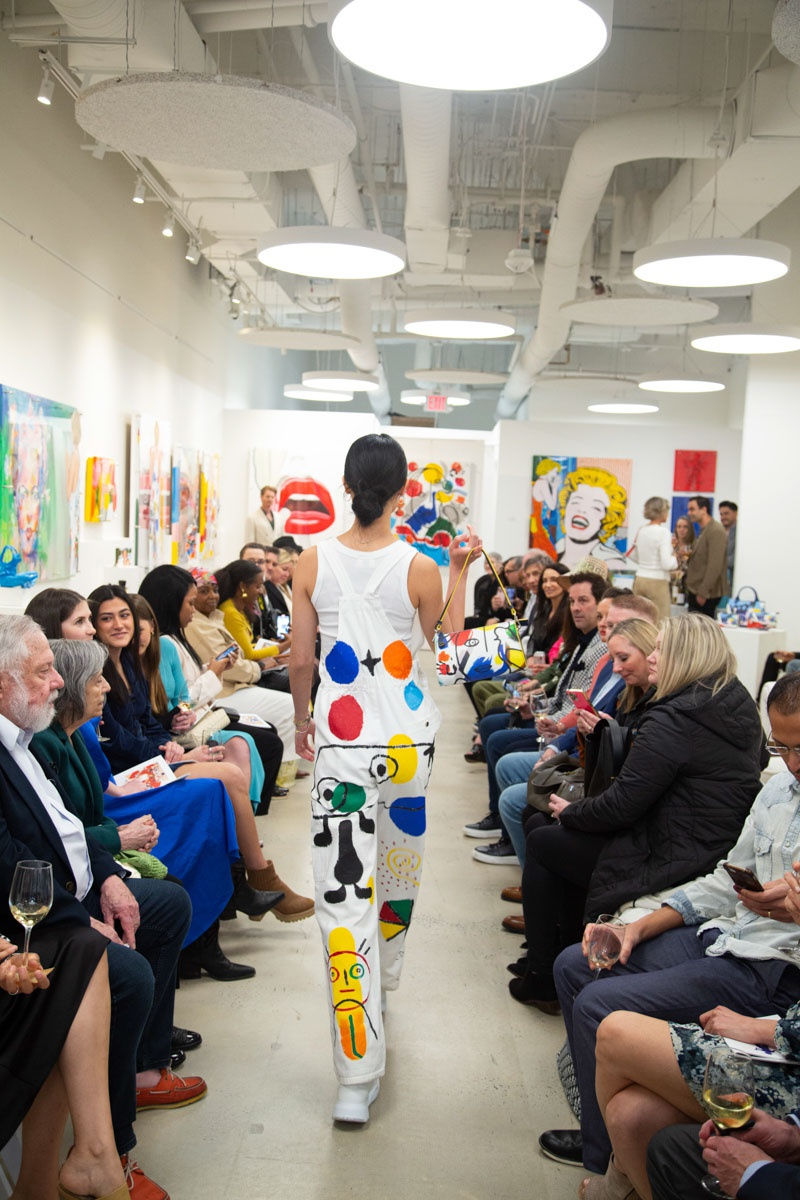Model walking down runway in gallery space in Buckhead Village, Atlanta during the Caroline Dechamby Retrospective.