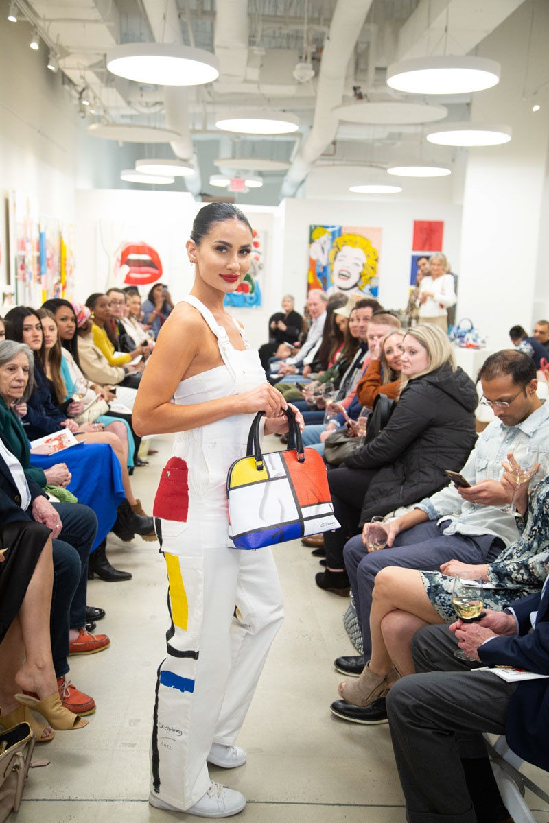 Model walking down runway in gallery space in Buckhead Village, Atlanta during the Caroline Dechamby Retrospective.