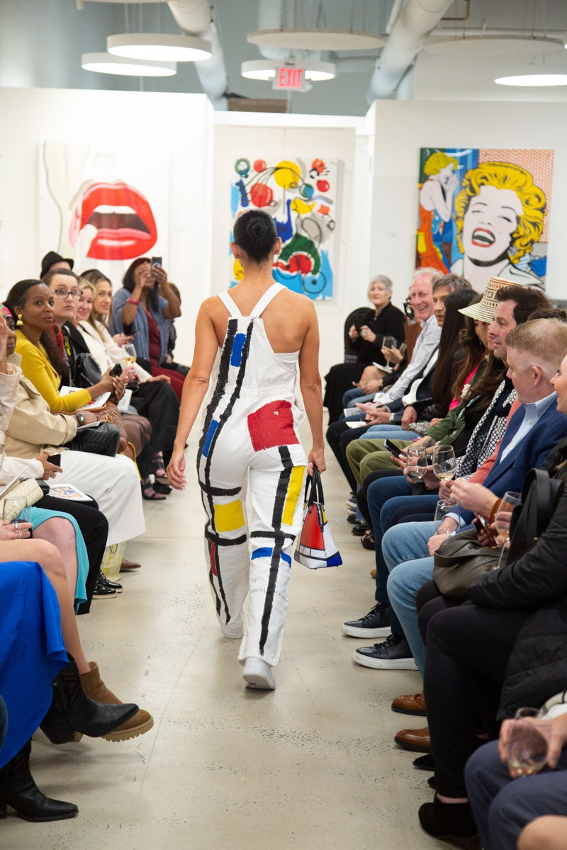 Model walking down runway in gallery space in Buckhead Village, Atlanta during the Caroline Dechamby Retrospective.