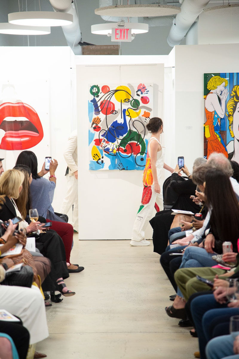Model walking down runway in gallery space in Buckhead Village, Atlanta during the Caroline Dechamby Retrospective.