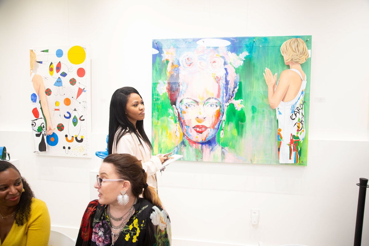 Woman staring at painting at Carousel Fine Art's gallery space in Buckhead Village, Atlanta during the Caroline Dechamby Retrospective.