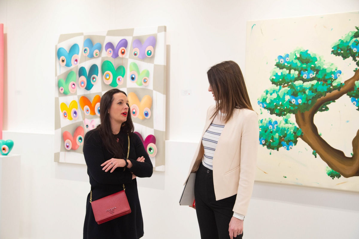 Women talking in Carousel Fine Art's Atlanta gallery space during the spotlight exhibition for John Westbay titled "Love, Outside the Lines."