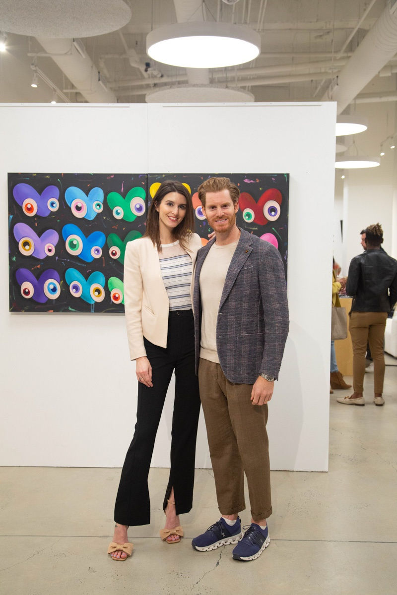 Gallery owners of Carousel Fine Art posing in front of John Westbay painting in Carousel Fine Art's Atlanta gallery space during the spotlight exhibition for John Westbay titled "Love, Outside the Lines."