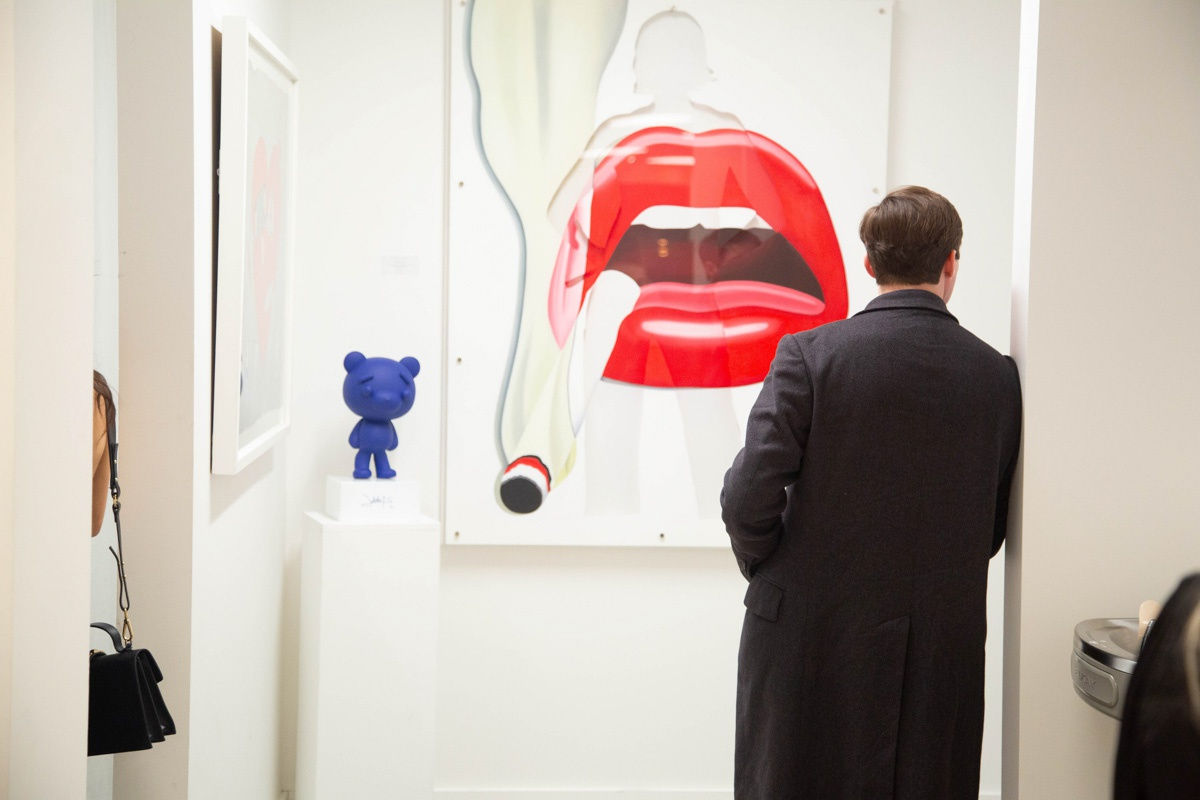 Man in front of painting by John Westbay in Carousel Fine Art's Atlanta gallery space during the spotlight exhibition for John Westbay titled "Love, Outside the Lines."
