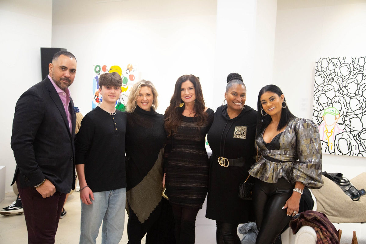 People posing in Carousel Fine Art's Atlanta gallery space during the spotlight exhibition for John Westbay titled "Love, Outside the Lines."
