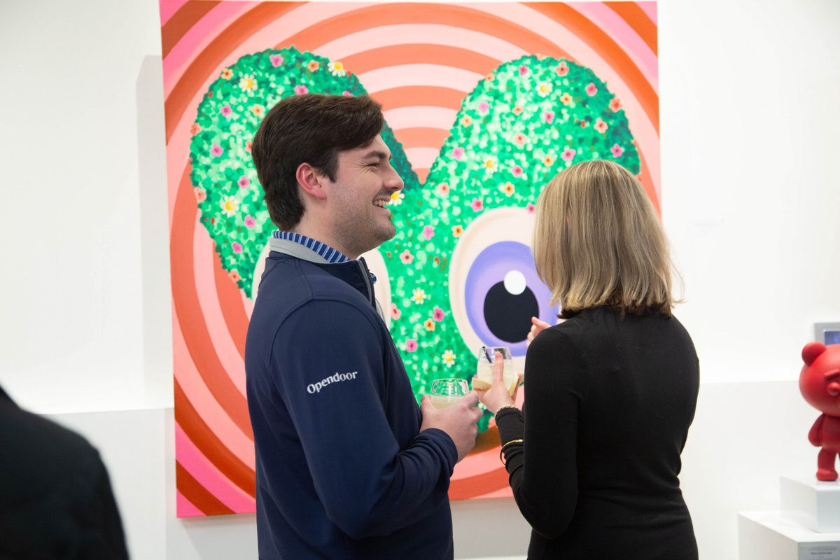 People in front of painting by John Westbay in Carousel Fine Art's Atlanta gallery space during the spotlight exhibition for John Westbay titled "Love, Outside the Lines."