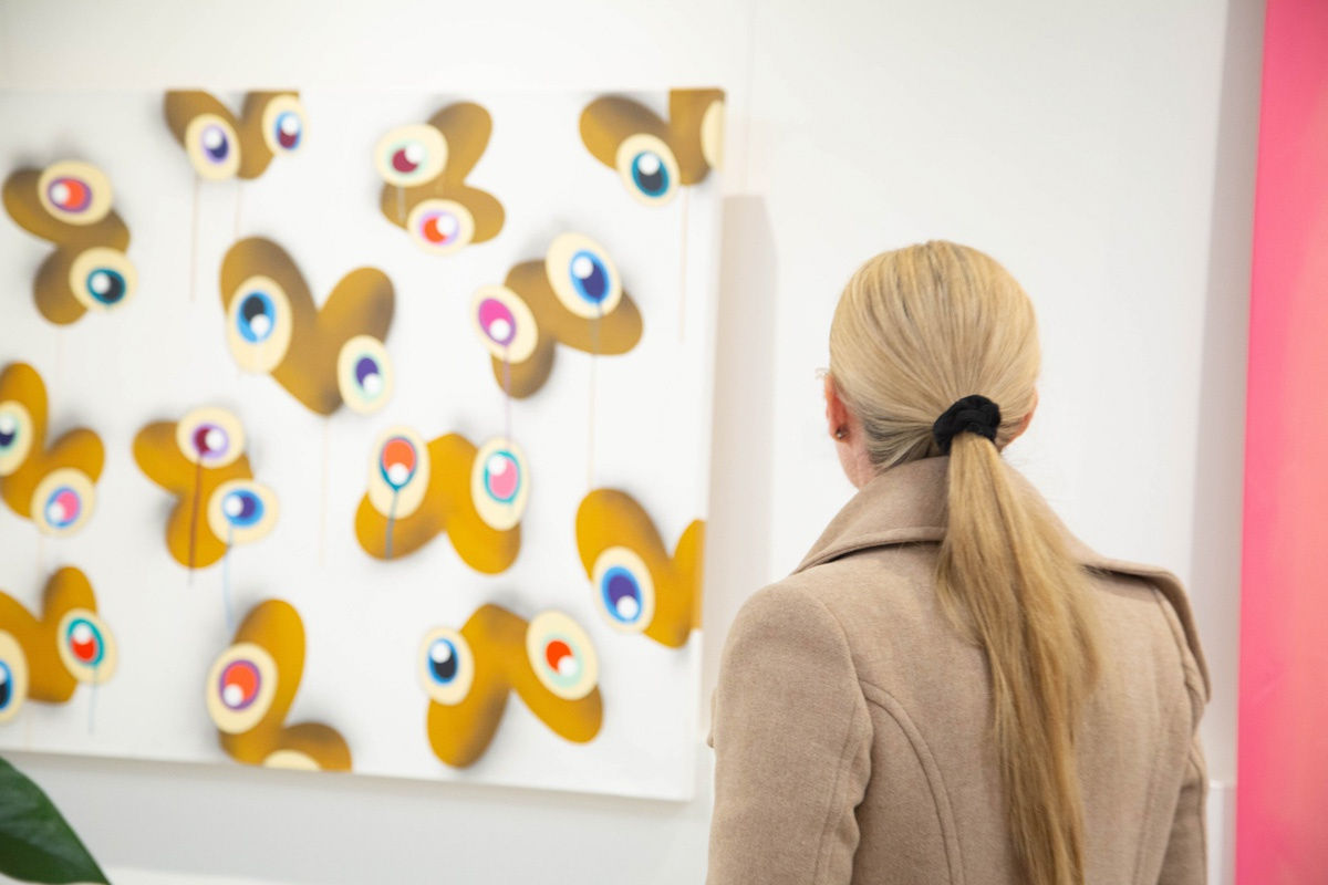 Woman staring at painting by John Westbay displayed in Carousel Fine Art's Atlanta gallery space during the spotlight exhibition for John Westbay titled "Love, Outside the Lines."