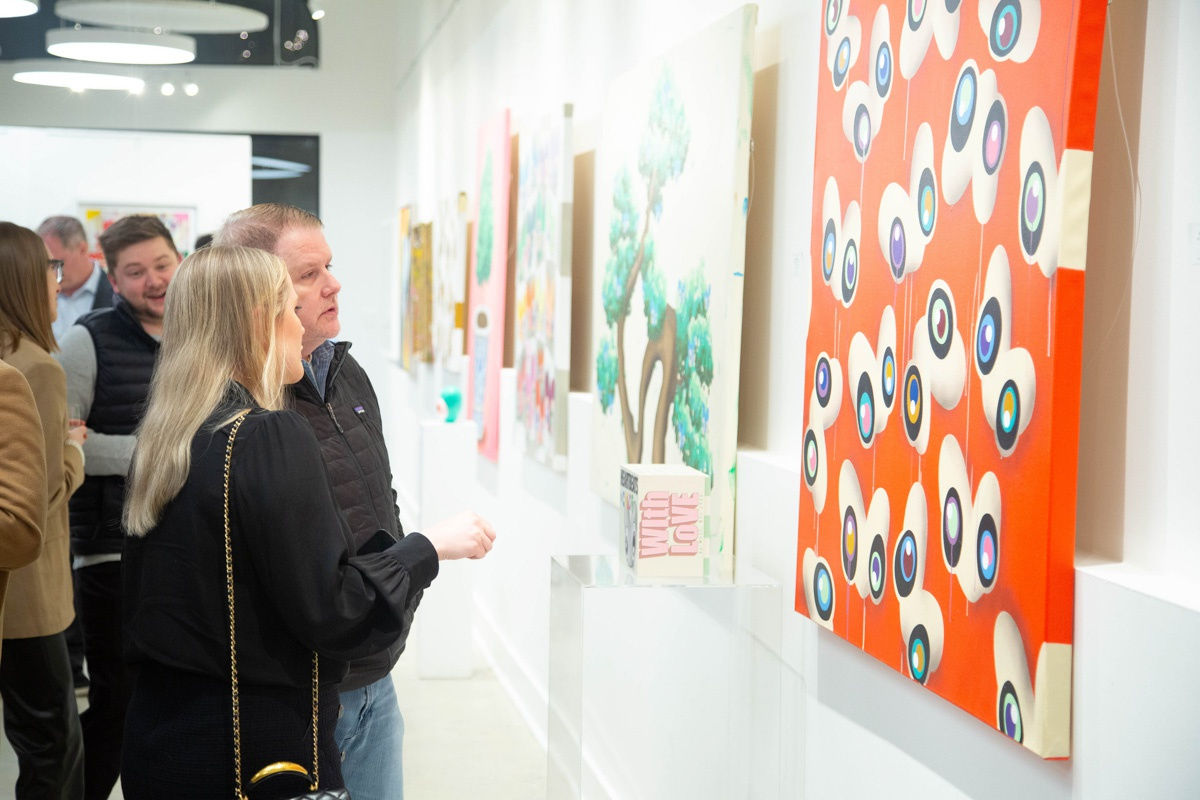 People staring at painting by John Westbay in Carousel Fine Art's Atlanta gallery space during the spotlight exhibition for John Westbay titled "Love, Outside the Lines."