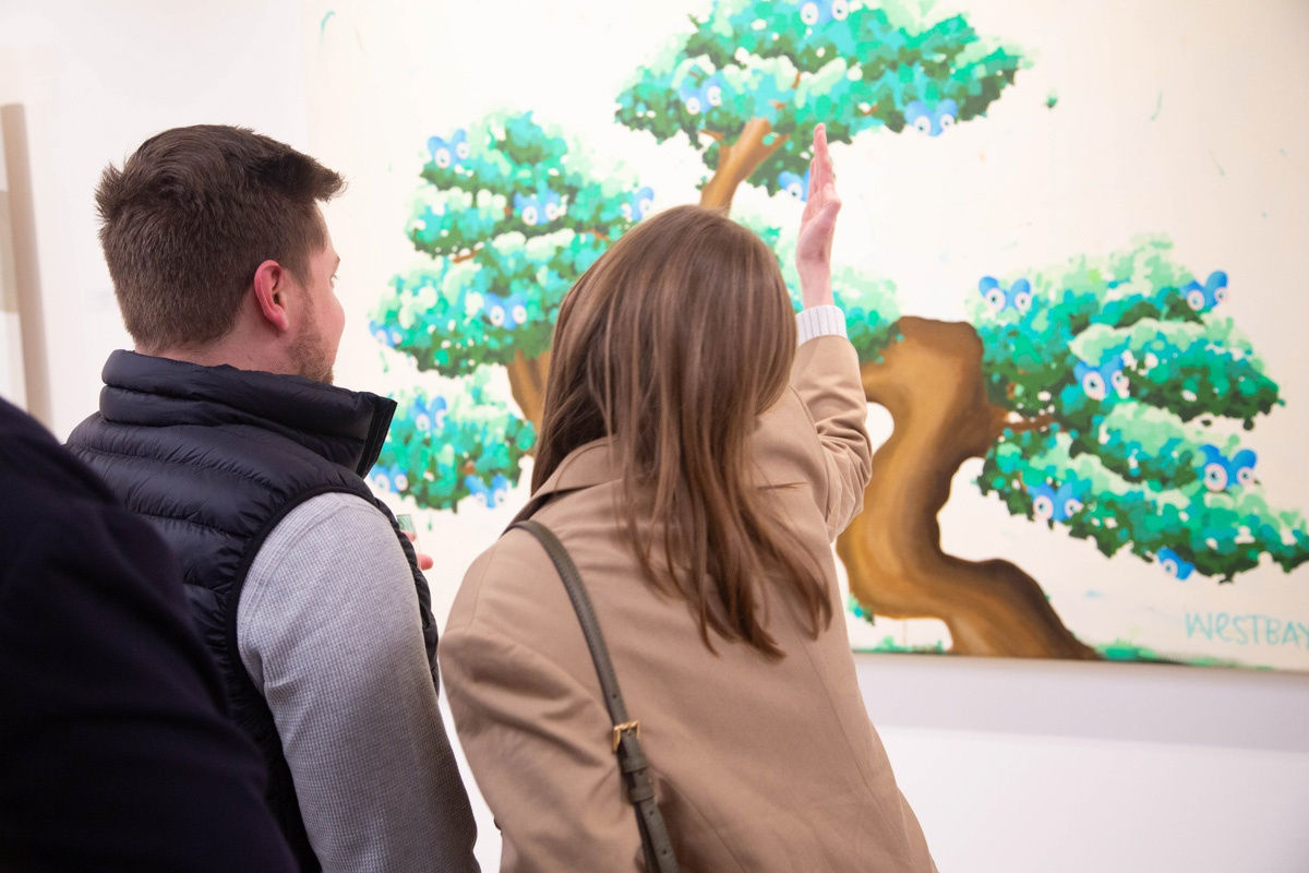 People staring at painting by John Westbay in Carousel Fine Art's Atlanta gallery space during the spotlight exhibition for John Westbay titled "Love, Outside the Lines."