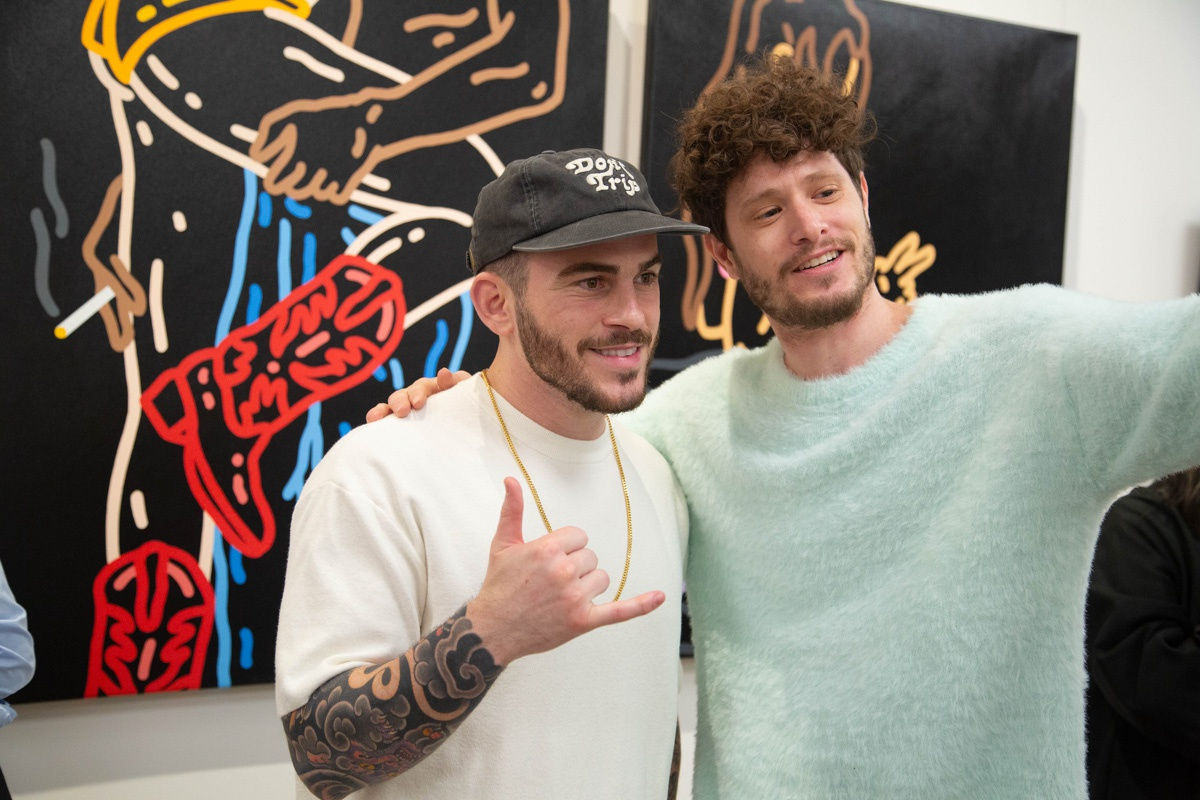 Artist John Westbay posing with man in Carousel Fine Art's Atlanta gallery space during the spotlight exhibition for John Westbay titled "Love, Outside the Lines."