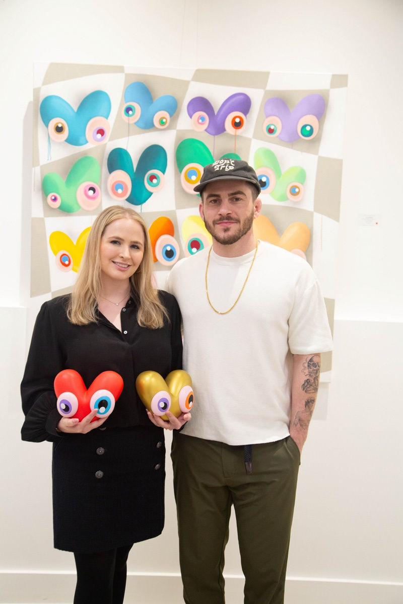 Woman posing with artist John Westbay Carousel Fine Art's Atlanta gallery space during the spotlight exhibition for John Westbay titled "Love, Outside the Lines."