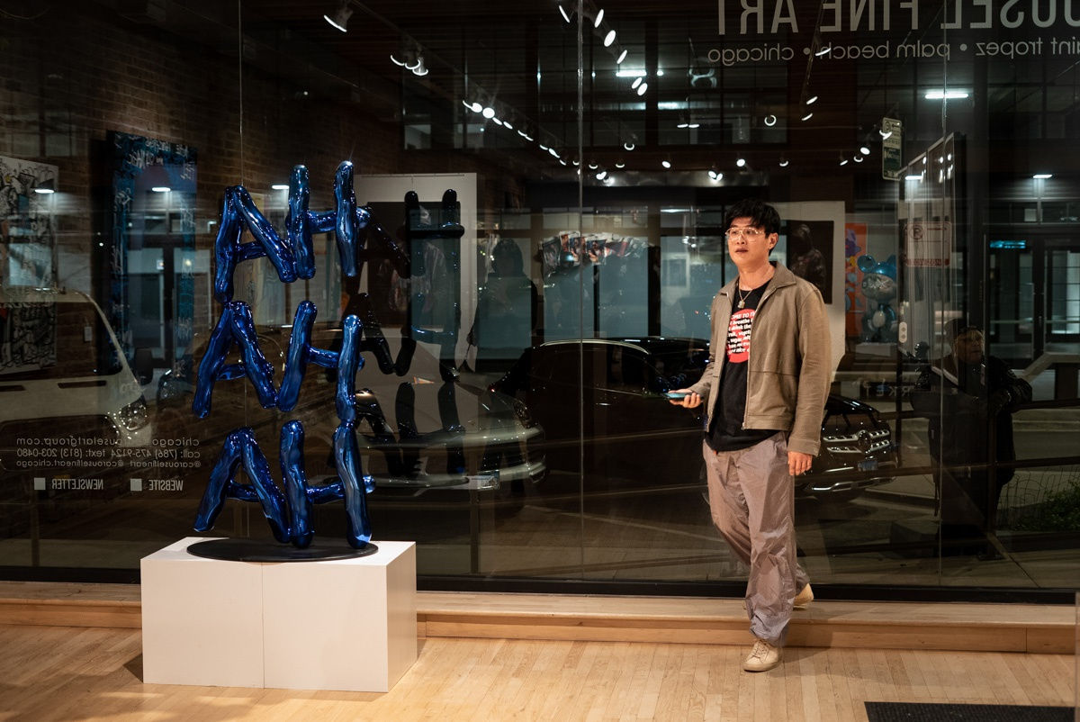 Man staring at paintings displayed in Carousel Fine Art's Chicago location during the Chicago Grand Opening.