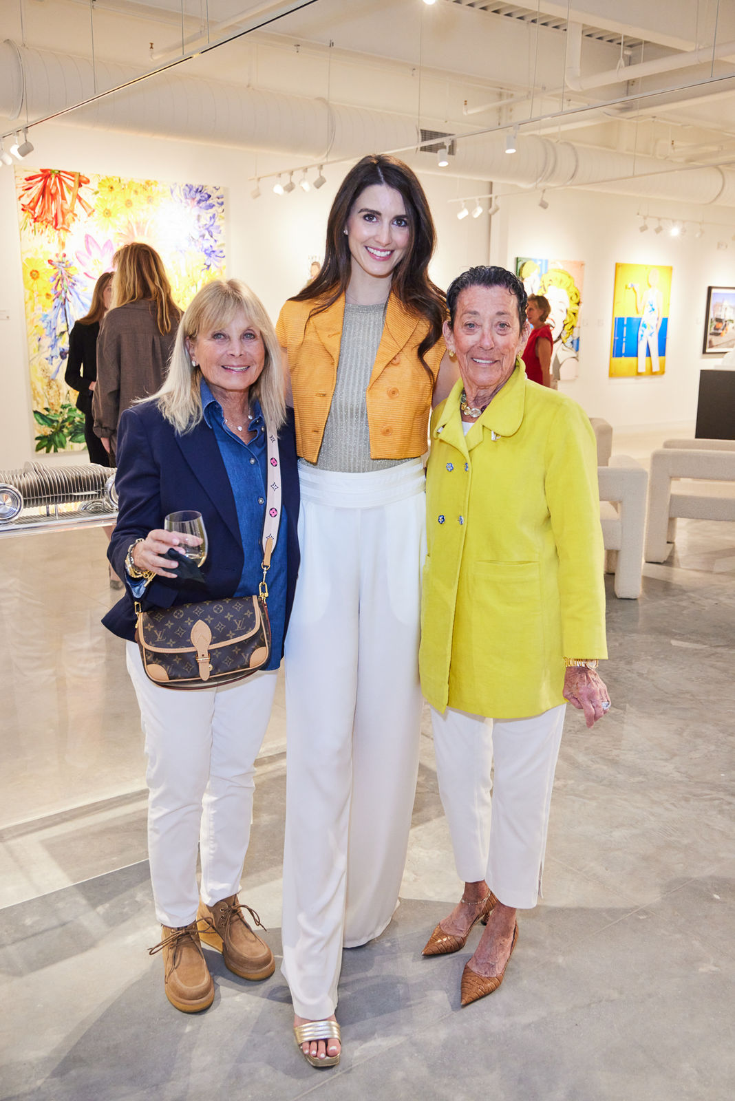 Gallery owner posing with VIP guests in front of the main feature wall at our West Palm Beach grand opening.