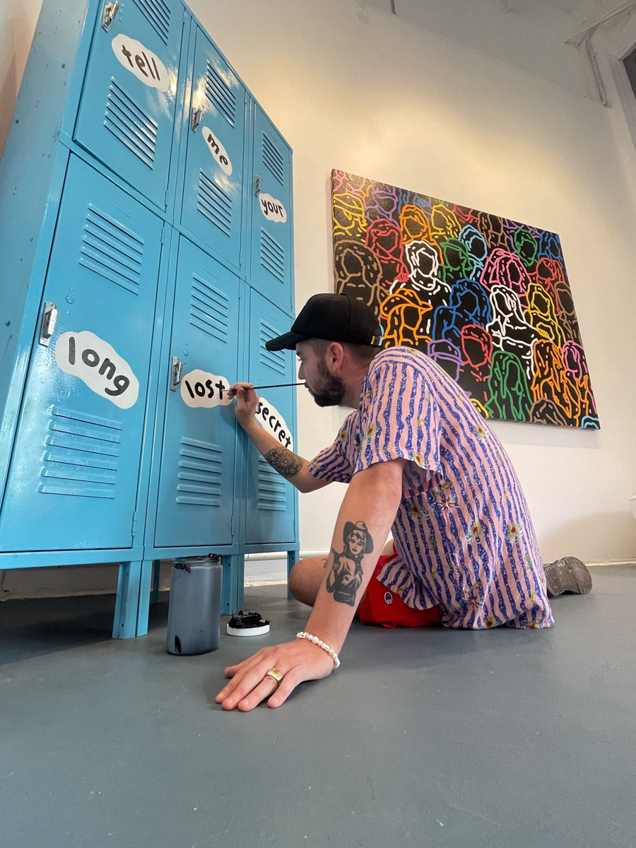 Artist Chance Cooper painting a locker at Carousel Fine Art's gallery space in Miami, FL during Chance Cooper's Spotlight Exhibition, "Between Me and You."