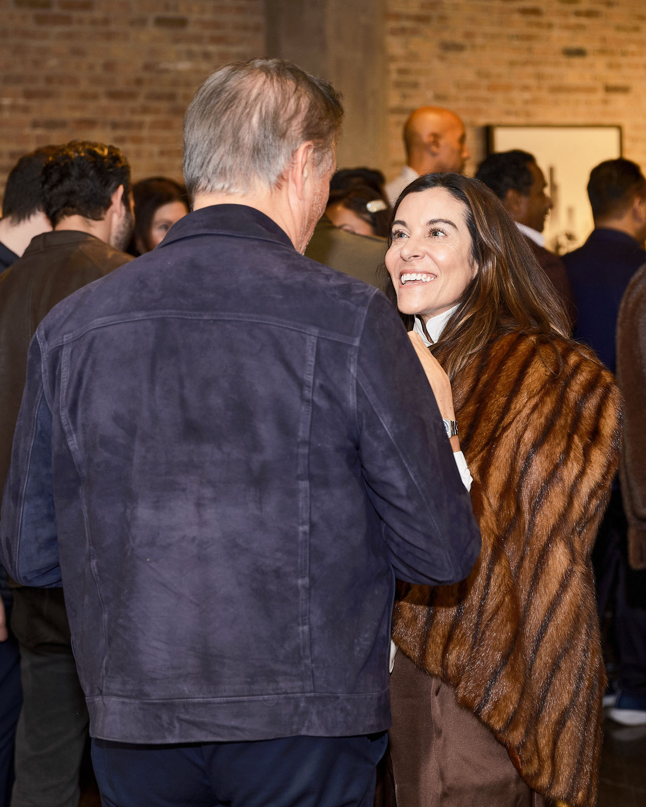 Friends laughing together while comparing mobile photos of Jason M. Peterson prints inside River North gallery.