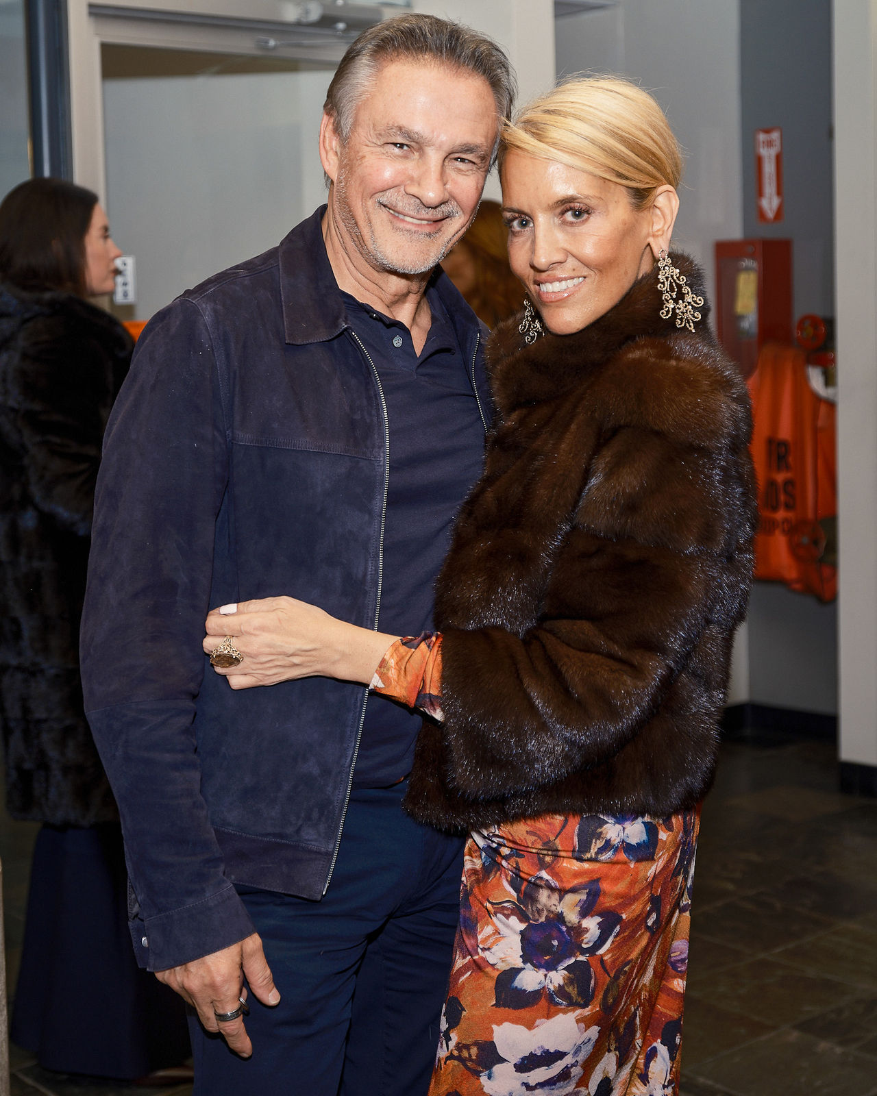 Collector couple posing arm in arm with Chicago skyline photograph by Jason M. Peterson behind them.
