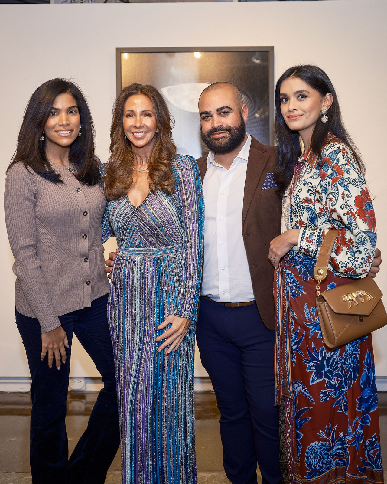 Group of guests smiling for the camera with Jason M. Peterson cityscape wall behind them at Chicago luxury event.