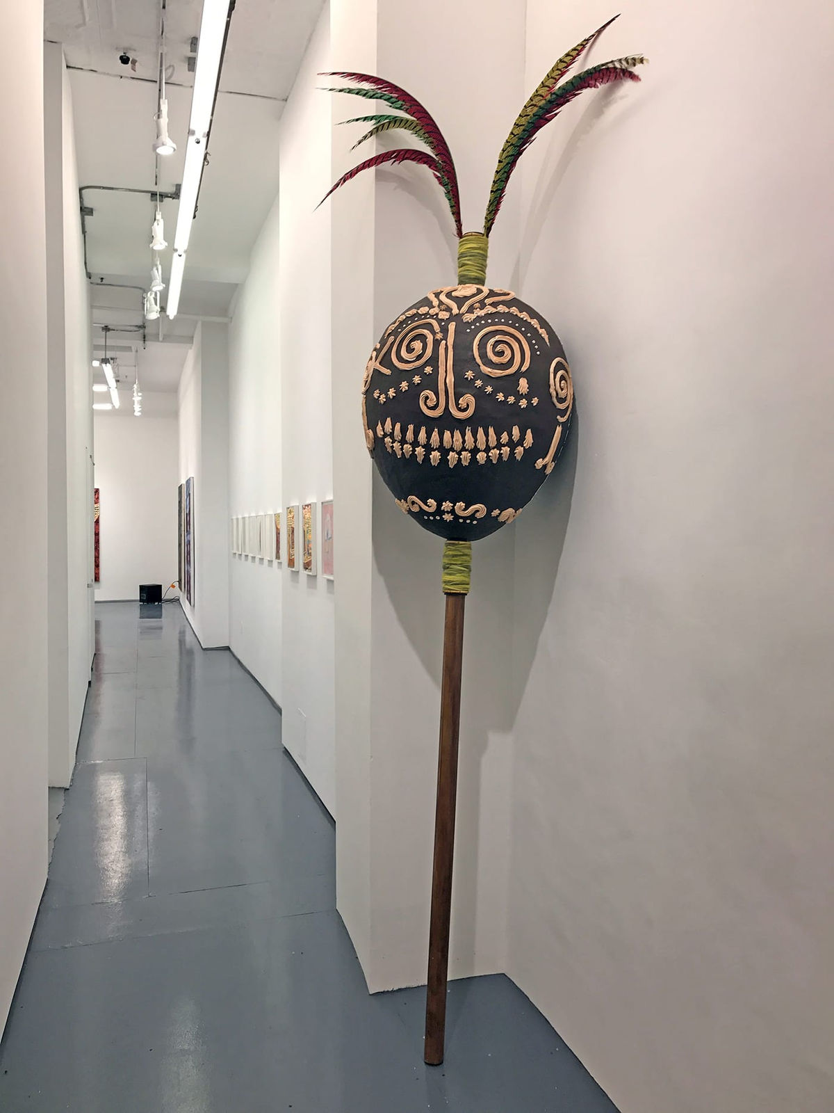 A large maraca sculpture near the entrance of the exhibition, “Maraca más grande con plumas” (2016)