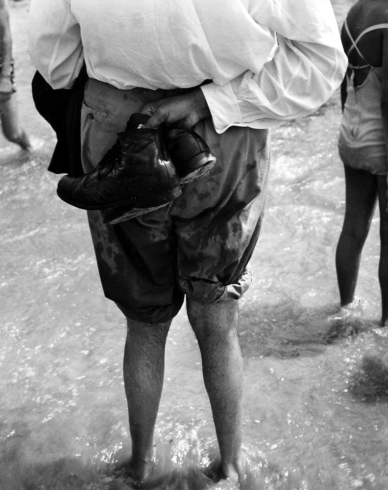 Leon Levinstein, Untitled (man in water holding shoes), c.1970