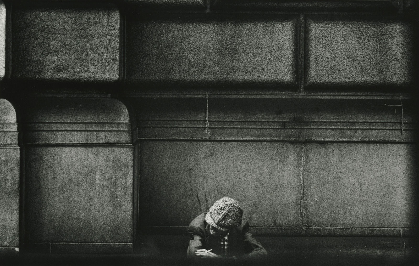 Larry Siegel, Man with cap seated against facade, NYC, 1959