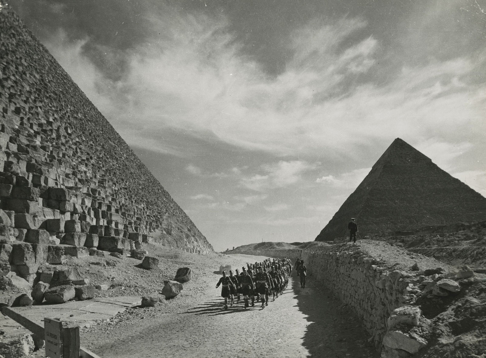 Margaret Bourke-White, British colonial troops, including Irish Cameron Highlands troops with Indian marching troops, as they march past the Great Pyramids, 1940