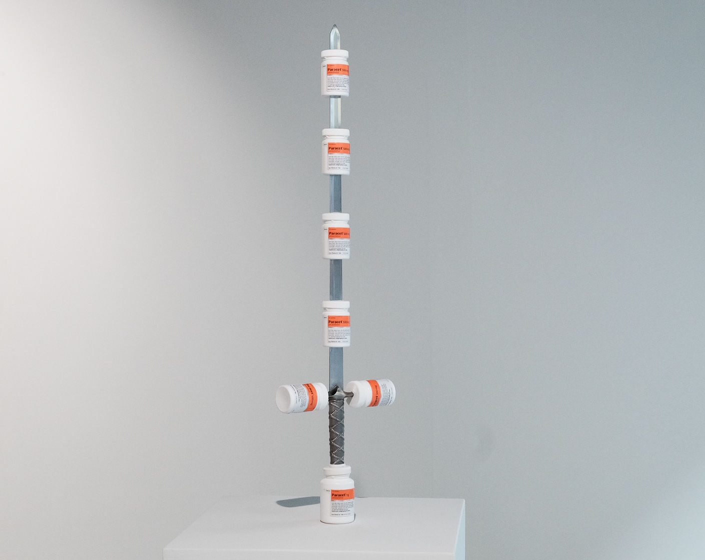 «Blade of Break-Through Pains», 2024 75x35cm, sword, cotton, 7 Paracet boxes with screw caps.