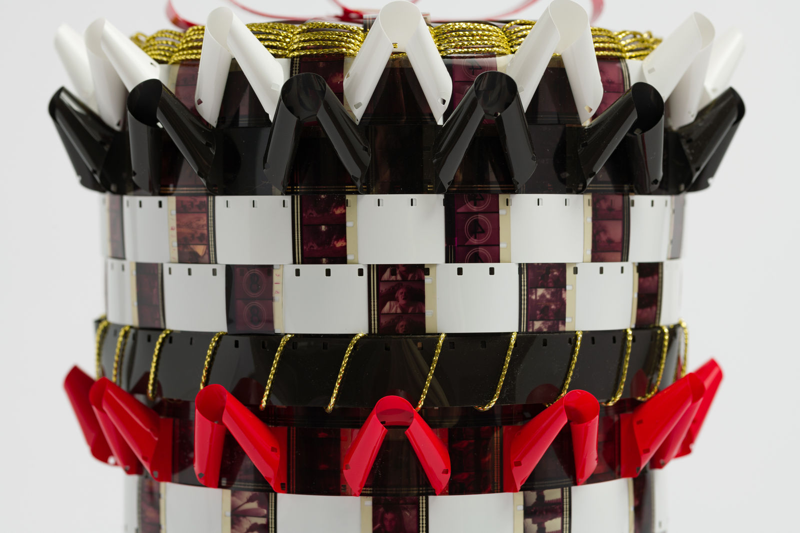 DETAIL Gail Tremblay The Ultimate 1976 Myth of a Nineteenth Century "Adopted" White English "Sioux" Wannabe, 2018 16mm film (The Return of a Man Called Horse, 1976); black, red and white 16mm film leader; gold metallic yarn, Scotch brand double sided tape. 10 1/2 x 7 x 7 in