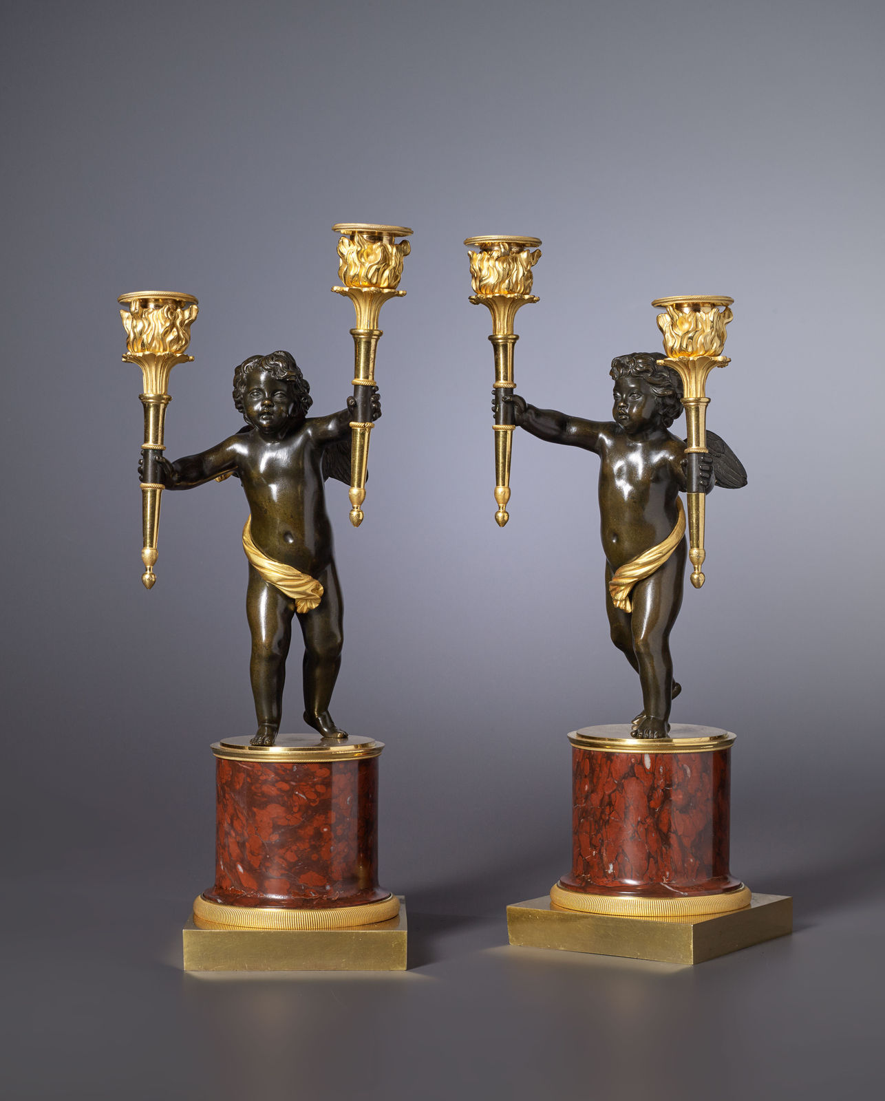 André-Antoine Ravrio (attributed to), A pair of Empire gilt and patinated bronze and rouge griotte marble two-light candelabra attributed to André-Antoine Ravrio, Paris, date circa 1805