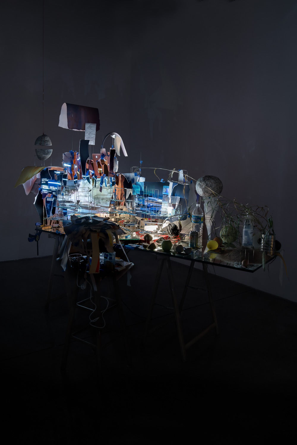 Sarah Sze installation in dark room of video projections on a desk