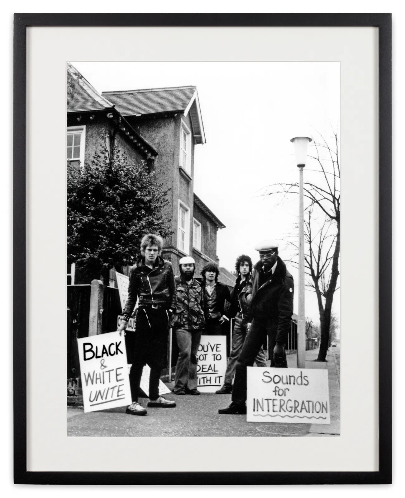 <div class="artist">Caroline Coon</div><div class="title_and_year"><span class="title">Paul Simonon (The Clash); Selwyn ‘Andy’ Brown (Steel Pulse); Glen Matlock (ex-Sex Pistols/The Rich Kids); Mick Jones (The Clash) and Mykaell Riley (Steel Pulse) demonstrate outside the head-quarters of the neo-fascist National Front on Connaught Road, Ted</span><span class="year">, 1978</span></div>