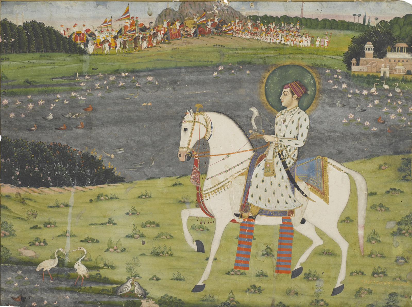 A young prince dressed in a long white jama patterned with green leaves outlined in gold is riding past a lake filled with lotuses and ducks