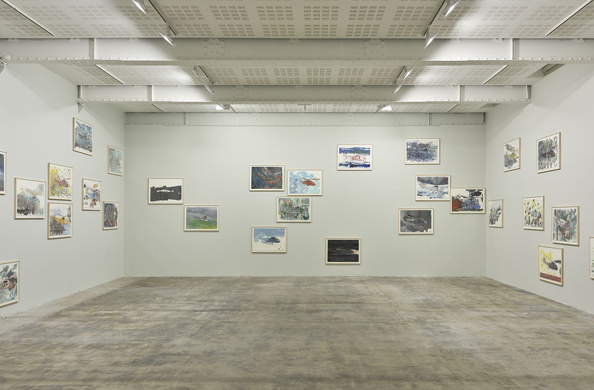 Many smaller, framed paintings on paper hung at various heights around 3 gallery walls. 