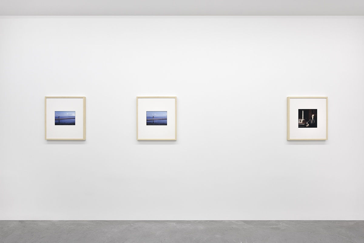 3 framed color photographs hang in a gallery.