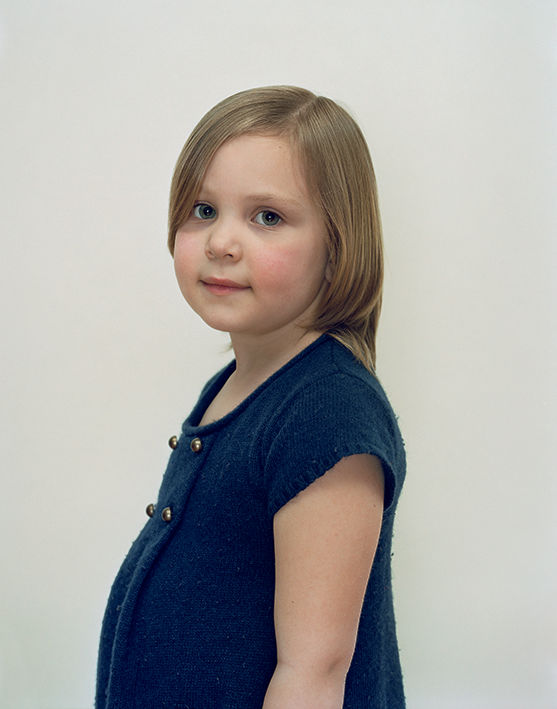 A Rineke Dijkstra portrait of a young girl in a blue shirt.