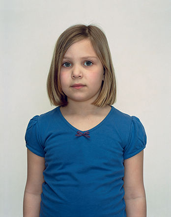 A Rineke Dijkstra portrait of a young girl in a blue shirt.