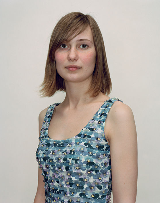 A Rineke Dijkstra portrait of a woman in a floral tank top with short hair.